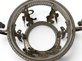 a silver plate with a design on it on a white surface