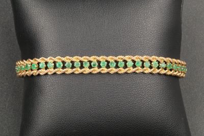 a gold bracelet with emerald stones