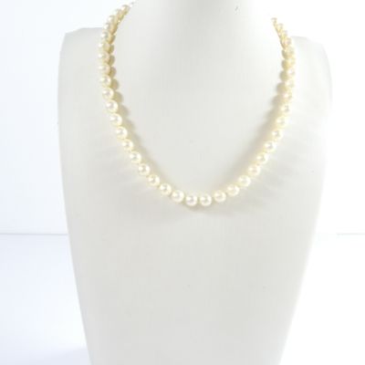 a close up of a necklace on a mannequin with a white background