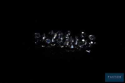a close up of a bunch of diamonds on a black surface