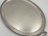 an oval silver tray with handles and beading around the edge