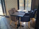 a table and chairs in a room with a brick wall