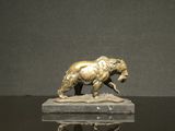 une statue en bronze représentant un ours, posée sur un socle en marbre