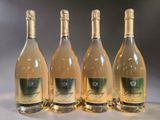 four bottles of wine are lined up on a table