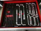 de nombreux outils dans une boîte à outils rouge posée par terre