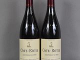 deux bouteilles de vin posées sur une table l'une à côté de l'autre