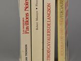 three books are stacked on top of each other on a table