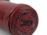a close up of a bottle of wine with a red cap