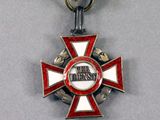 an image of a medal with a red ribbon and a white cross on it