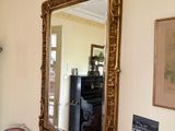 a mirror on the wall above a table with a chair