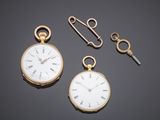 two gold pocket watches and a key on a black surface