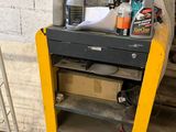 un établi avec une étagère jaune au milieu de la pièce