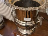 a silver vase sitting on a wooden table in a living room