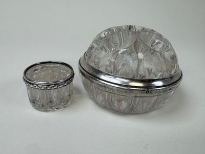 a glass container with a silver lid next to a glass cup