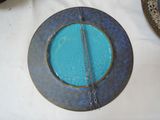 a blue plate on a table with a chain hanging from it