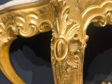 an antique console table with a marble top and gold leaf decoration