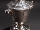 an antique silver plated sugar dish with a lid on a black surface