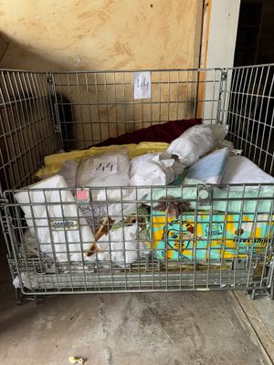 une cage métallique remplie d'articles pour bébés dans une pièce