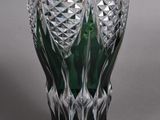 a green glass vase sitting on top of a table