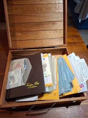 une boîte en bois remplie de papiers et d'autres objets, posée sur une table