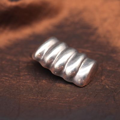 a small silver object on a brown cloth