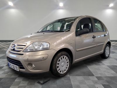 une photo d'une petite voiture beige garée dans un garage