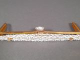 an image of a gold and white lace bridalle with a flower