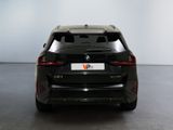 the rear end of a black bmw suv parked in a room