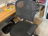 une chaise de bureau noire assise devant un bureau d'ordinateur