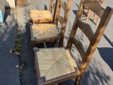 quatre chaises en bois posées au bord de la rue