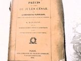 un vieux livre posé sur une table sur laquelle se trouve une horloge