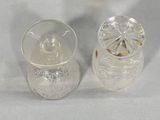 two clear glass jars sitting next to each other on a table