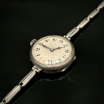 une montre en argent avec des chiffres romains sur un cadran noir