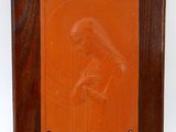 une plaque orange représentant une femme tenant un bébé dans ses bras