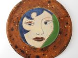 painting of a woman ' s face with blue hair in a circular frame
