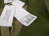 a green jacket with a tag on it sitting on a table