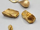 two pieces of gold are sitting next to each other on a table