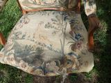 a chair that is sitting in the grass with a pillow