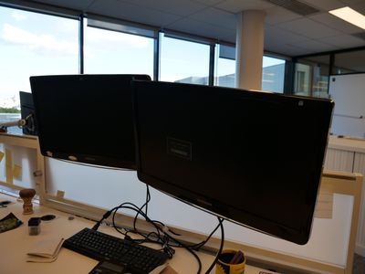 deux écrans d'ordinateur sur un bureau avec un clavier et une souris