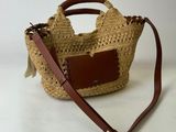 une photo d'un sac en paille muni d'une anse en cuir marron