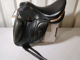 a black saddle on a white table next to a box