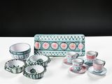 several cups and saucers are sitting on a table with a box in the background