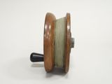 an image of a reel with a wooden handle on a white surface