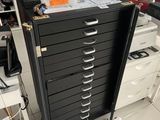 a black filing cabinet with many drawers in a room