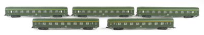 four green train cars are lined up on a white surface