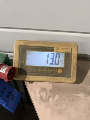 un compteur numérique posé sur une table à côté d'une paire de fils électriques