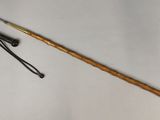 a wooden stick with a metal handle next to a crochet hook
