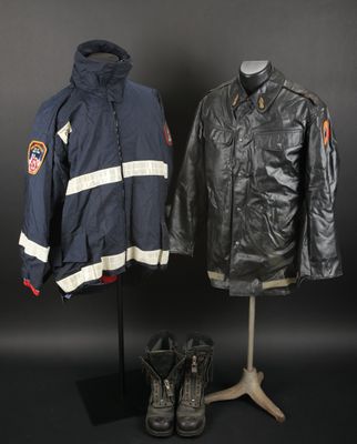 deux vestes et une paire de bottes posées sur un présentoir pour mannequin