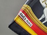 a close up of a person ' s hand holding a black and yellow scarf with a white horse on it