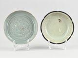 pair of blue and white plates with designs on them on a stand